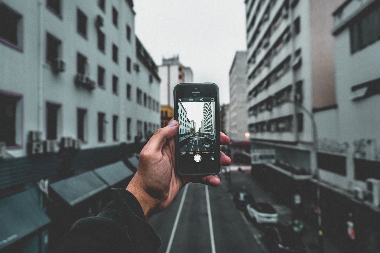 A city street view captured through a smartphone, highlighting urban architecture and perspective.